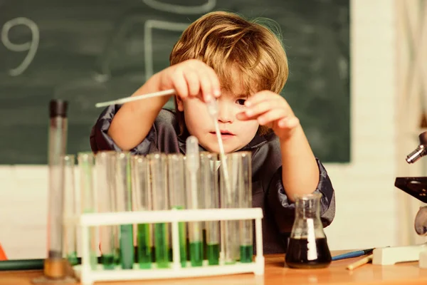 Een klein kind dat scheikunde leert in een schoollaboratorium. experimenteren met chemicaliën Kleine jongen bij de chemische kast. Een jongen in een lab met scheikundeles. Terug naar school. Bloedmonster testen — Stockfoto