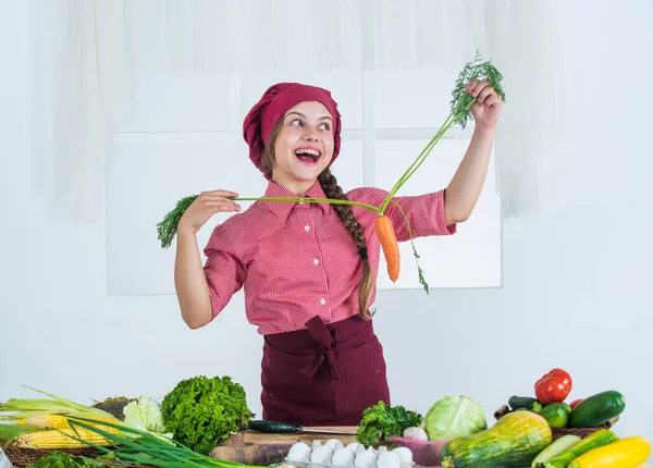 Zu viel Spaß. Mädchen mit Karotte voller Vitamine. Ernährung und Gesundheit. Kinder haben Spaß mit Gemüse in der Küche. Kind und Gemüse. Gesunde Ernährung und Lebensstil-Konzept. Grüne vegetarische Kost — Stockfoto