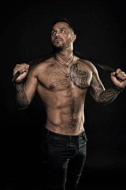 Fitness modeli üstsüz. Sağlık hizmeti yaşam tarzı. Vücut kasları güçlü. Vahşi erkeksi güzellik. Maço. vahşi ve seksi. Vücut dövmesi olan kaslı bir vücut geliştirici. Atletik erkek güçlü bir kemer tutuyor. Güç dolu.