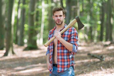 İçindeki oduncuyu serbest bırakıyorsun. Yakışıklı adam doğal manzarada balta taşıyor. Yaz tatili. Doğa yolculuğu. Doğal ortam. Ekoloji ve ekosistem. Ağaç kesme. Ormana yolculuk