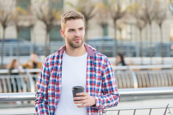 casual dressed male drinking morning coffee from cup. unshaven guy with bristle in urban style. modern life concept. student drink tea. handsome young man wear checkered shirt. Breakfast time