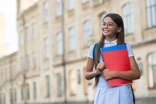 Erlauben Sie sich, Anfänger zu sein. Glückliches Kind in Brille hält Bücher in der Hand. Zurück zu den Grundlagen der Schule. Schulbibliothek. Wissenstag. Formelle oder informelle Bildung. Fangen Sie an, groß zu sein, kopieren Sie Platz — Stockfoto