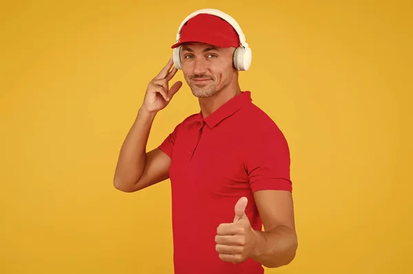 This song is so good. Unshaven man give thumbs up yellow background. Like and approval sign. Handsome guy listen to song. Modern life. New technology. Enjoying song playing in headphones — Stock Photo, Image