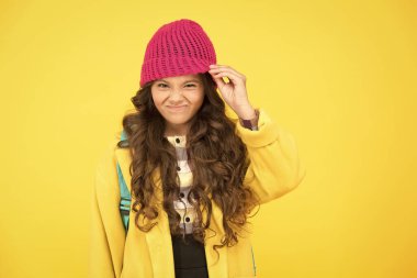 Şapka beni gerçekten rahatsız ediyor. Küçük çocuk şapka takmaktan hoşlanmıyor. Küçük çocuk sarı arka planda şapkasını çıkarıyor. Resmi sonbahar tarzında tatlı bir çocuk. Güzel görünümlü küçük bir çocuk okula gidiyor.