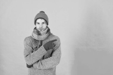 En iyi teklif burada. Tıraşsız yakışıklı adam mavi arka planda kış aksesuarları takıyor. Kış sezonu indirimi. Hippi, kış şapkası eşarbı ve eldiven ördü. Erkek güzeli. Alışveriş konsepti. Kıyafet dükkanı.