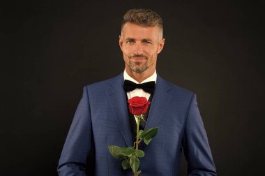 Lovely face of male. groom in tuxedo with rose. during wedding ceremony. groom in wedding jacket. bowtie is principal element for men. fashionable man with flower. groom man in suit. elegant boy clipart