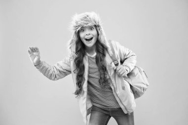 Sırt çantalı liseli kız evine git. Okul yılının sonunda. Artık sınav yok. Küçük mutlu kız okula geri döndü. Kış tatili ve tatil. Çocuk sıcak kıyafetleri pembe arka plan. Mutlu çocuk kulaklığı.