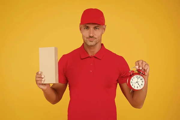 Take your shopping time. Delivery man hold clock and box yellow background. Online shopping. Cyber Monday. Sales shopping. Shopping and fast delivery. Time to shop, copy space