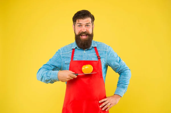 Cozinheiro feliz segurar tomate na faca para cozinhar alimentos saudáveis fundo amarelo, saúde — Fotografia de Stock