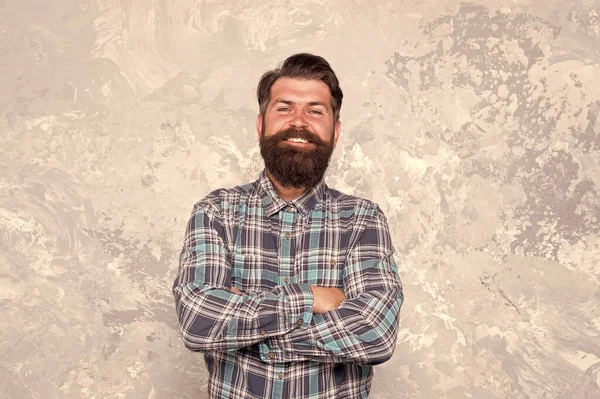 Homem maduro modelo de boa aparência. homem feliz com barba e bigode. hipster carismático na barbearia. cabeleireiro profissional em camisa. homem barbudo brutal grunge fundo. masculino com braços cruzados — Fotografia de Stock