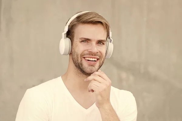 Fejméretre alkalmas fejhallgató. A boldog fickó szürke fülhallgatót visel. Jóképű férfi mosolyog fülhallgatóval. Modern tervezésű fejhallgató. Új technológia. Élj hangosan! — Stock Fotó