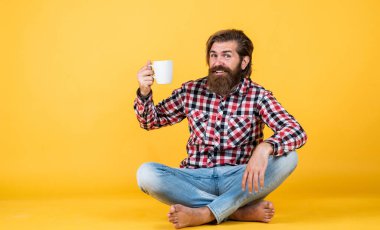 Bunu dene. Adam fincandan sıcak çay içiyor. Sana da günaydın. Enerjik, sıcak bir içecek. İlham için biraz kahveye ihtiyacım var. Güne mükemmel bir başlangıç. Mutlu sakallı adam sabah kahvesini içiyor.
