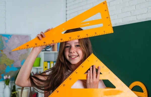 Linda chica adolescente cerca de pizarra con regla de herramienta de triángulo matemático, de vuelta a la escuela — Foto de Stock