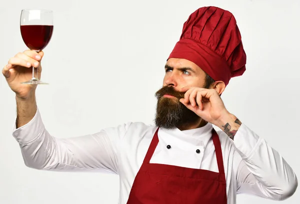 Kocken håller upp ett glas rött vin. Man med skägg — Stockfoto