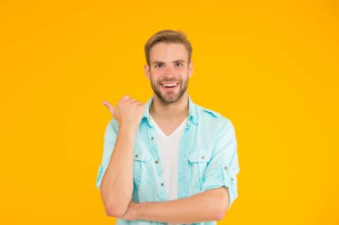 Sarı arka planda sıradan gömlekli, traşsız genç adam, berber dükkanı.