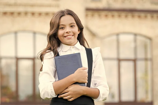 Aprendendo linguagem. Ligado à aprendizagem. Vida escolar. Desenvolvimento infantil. Entusiasmado por estudar. Conceito de educação escolar. Bonito livro infantil sorridente. Uma aluna de escola. Dia do conhecimento — Fotografia de Stock