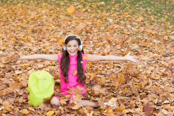 Felice ragazza di buon umore vomitare foglie autunnali, tempo di scuola — Foto Stock