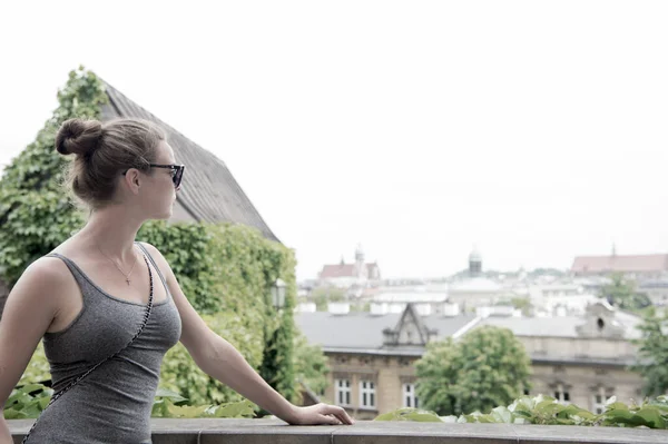 Fille lunettes de soleil touristiques profiter de la vue Cracovie vieille ville. Femme debout en face de l'horizon architectural avec des toits et clochers vieux espace de copie de la ville. Doit visiter un endroit. Guide pour les touristes à explorer Cracovie — Photo