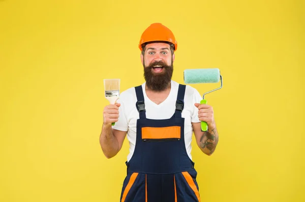 Glückliche Maler in Arbeitskleidung halten Farbwalze und Pinsel Malwerkzeuge für Bau- und Bauarbeiten, Veredelungsarbeiten — Stockfoto