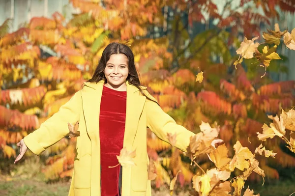 秋の暖かい。葉が落ちる。秋の公園を歩く秋のコートのスタイリッシュな女の子。落ち葉。秋の自然。葉で幸せな小さな子供の屋外遊び。晴れた日に公園を歩く少女。お楽しみください — ストック写真