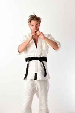 Adam siyah kuşaklı beyaz kimonoyla poz veriyor. Japon karatesi