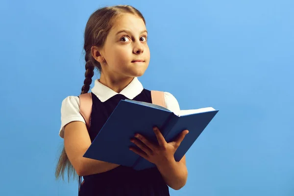 Regreso al concepto de escuela y educación. Chica sostiene libro azul —  Fotos de Stock