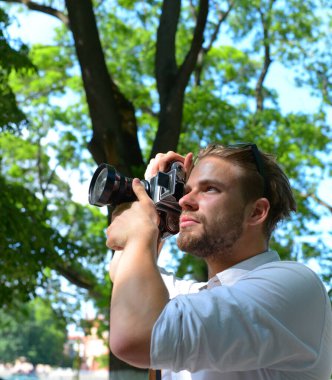 Fotoğrafçı büyük mercekli retro kamera tutuyor.