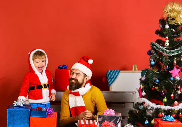 Familia de Navidad abre regalos sobre fondo rojo — Foto de Stock