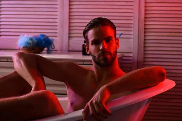 Sukupuoli ja erotiikka käsite: macho istuu punainen valaistu kylpyhuone — kuvapankkivalokuva