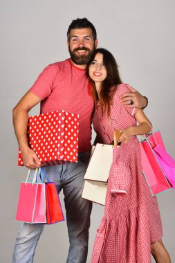 Sakallı bir adam ve gülen yüzlü bir kız alışveriş yapıyor..