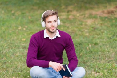 Üniversite parkında açık havada okuyan yakışıklı bir öğrenci.