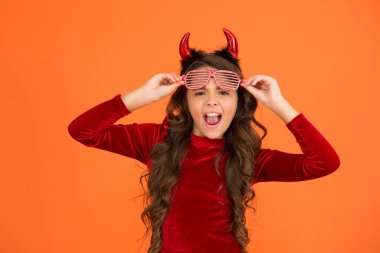 Görünüşte moda. Karnaval kostüm partisi. Şeker mi şaka mı? Bayramları kutlarız. Mutlu cadılar bayramı şeytan kızı. Boynuzlu ergen bir çocuk. Neşeli çocuk komik parti gözlükleri takıyor. Eğlenme zamanı.