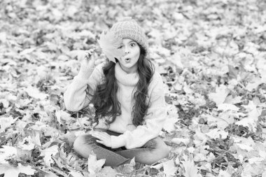 Şapkanı sıcak tut. Çocuk sıcak yumuşak örülmüş şapka takıyor. Neşeli bir ruh hali. Sıcak yün aksesuar. Uzun saçlı, gülen yüzlü bir kız. Bu sonbaharda seni sıcak tutar. Açık havada sarı şapkalı çocuk