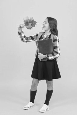 Sonbahar döneminin başında. Okul eğitimi konsepti. Sonbahar sezonunun tadını çıkaran kız. Çalışmaya devam et. Okul çantalı ve sonbahar yapraklı küçük okul kızı. Çalışmak için sonbahar zamanı