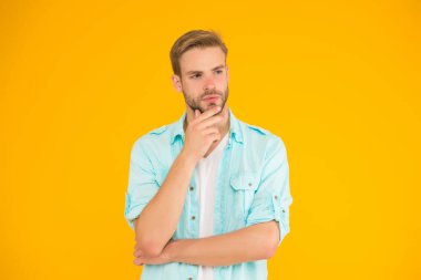 Erkek doğal güzelliği. Moda mankeni. Sıradan gömlek giyen sakallı seksi adam. Erkek bahar modası. Erkek yüz bakımı ve güzellik. Modayı takip eden saç kesimi. Tıraşsız suratlı dalgın bir adam.