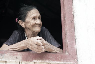 Pencerede gülümseyen yaşlı kadın