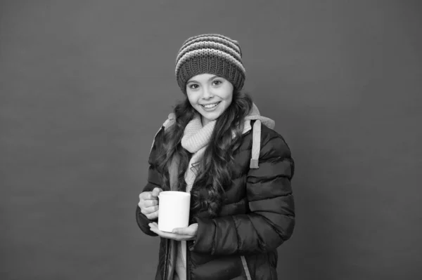 Time to get energy. Happy child enjoy hot drink on winter day. Small girl hold tea or cocoa cup red background. Hot energy drink. Energy boost. Boosting energy in morning — Stock Photo, Image