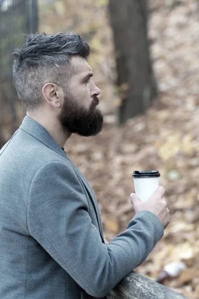 Sakallı hippi adam kahveyi tercih ediyor. İş adamı sakallı adam dışarıda kahve içer. Hippi elinde kağıt kahve fincanı tutar ve park ortamının tadını çıkarır. Kahve molası. Giderken iç. — Stok fotoğraf