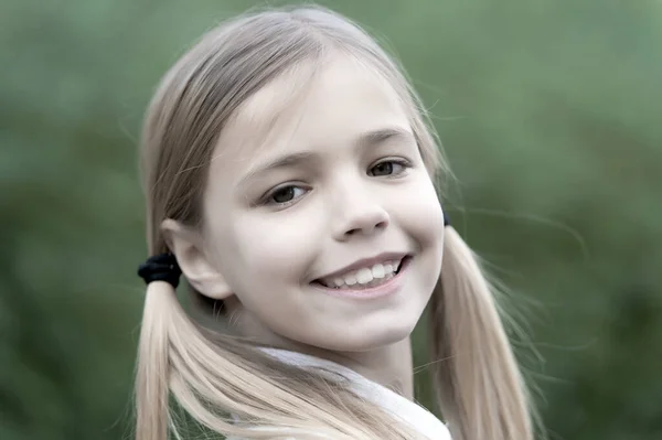 Kleines Mädchen lächelt auf natürlichem Hintergrund, Kindheit — Stockfoto