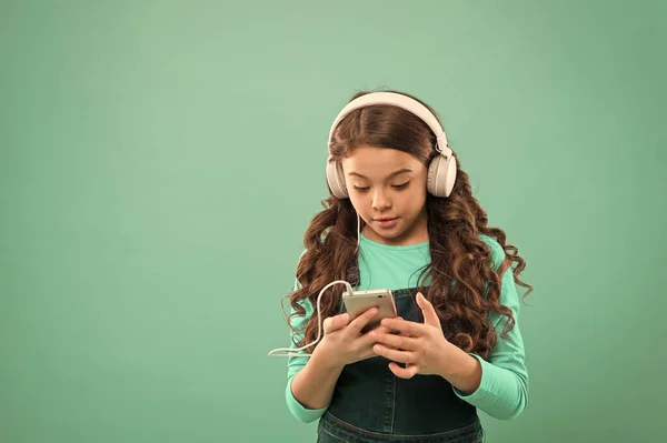 Online entertainment. Free music apps. Listen for free. Get music account subscription. Small girl child listen music modern headphones and smartphone. Enjoy music concept. Enjoy perfect sound