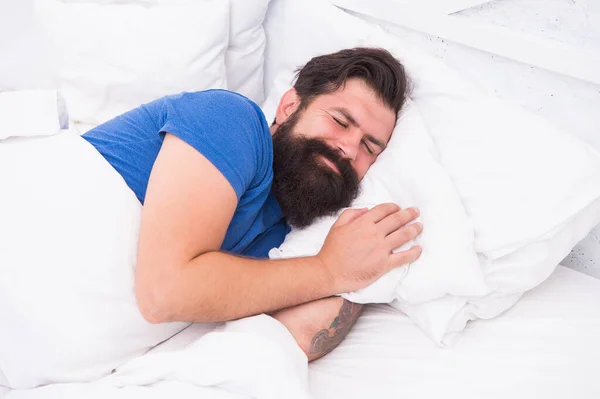 Hombre caucásico brutal complacido con bigote sonriendo en la cama en habitación luminosa, estilo de vida saludable — Foto de Stock