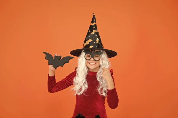 Varázsló vagy bűvész. Halloween buli. Fotófülke kellékek. Egy kislány fekete boszorkány kalapban. Őszi szünet. Csatlakozz az ünnepléshez. Boszorkányjelmezes kisgyerek. Varázslat. Kis boszorkány ősz hajjal — Stock Fotó