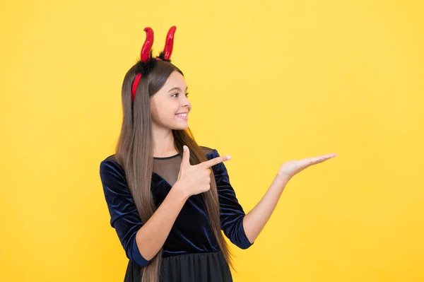 Glücklich Hexe Teenager Teufel Mädchen zeigt mit dem Finger auf Kopie Raum tragen Wichtel Hörner Kostüm auf halloween party, halloween party — Stockfoto