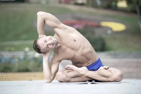 Uomo atletico che fa asana yoga nel parco — Foto Stock