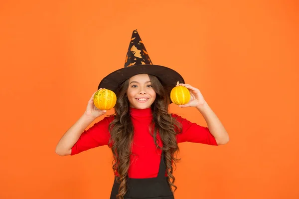 Criança feliz no traje de chapéu de bruxa para halloween com pequena abóbora amarela, comida de halloween — Fotografia de Stock