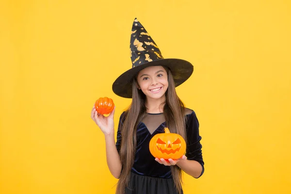 Happy witch kid with pumpkin jack o lantern wear costume of wizard on halloween party, halloween atribute — Stock Photo, Image