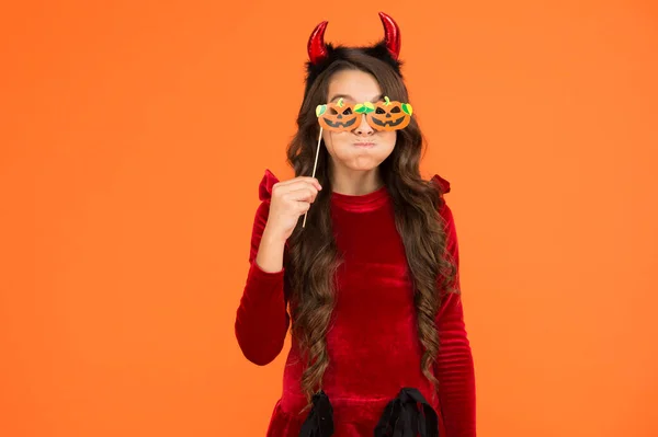 Niño de Halloween en traje e imp hors con gafas de fiesta de calabaza hace caras emocionalmente, día de fiesta de Halloween — Foto de Stock