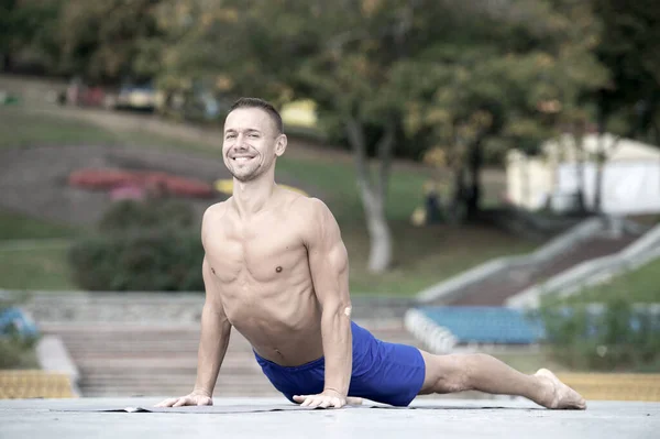 Hombre atlético haciendo asanas de yoga en el parque —  Fotos de Stock