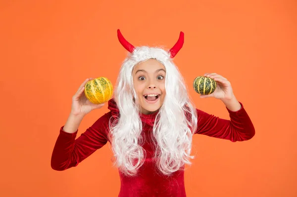 幸せな女の子は長い白い髪のウィッグを持っている悪魔の角を身に着けているハロウィンカボチャ、幸せなハロウィンの伝統 — ストック写真