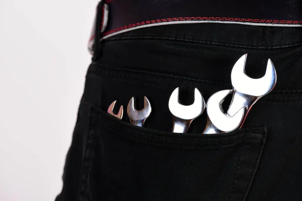 Outils de clé dans la poche du jean sur fond blanc. — Photo